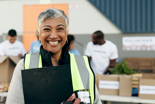 Smiling volunteer holding printed materials